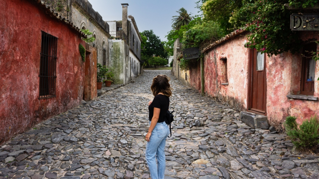 A woman standing in the middle of the cobblestone street in Colonia del Sacramento, Uruguay.